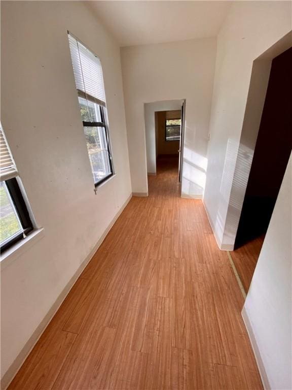 hallway featuring light wood-type flooring and baseboards