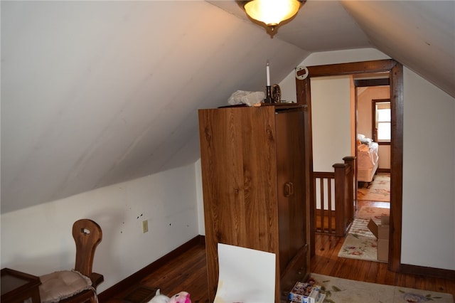 bonus room with dark wood-type flooring and lofted ceiling