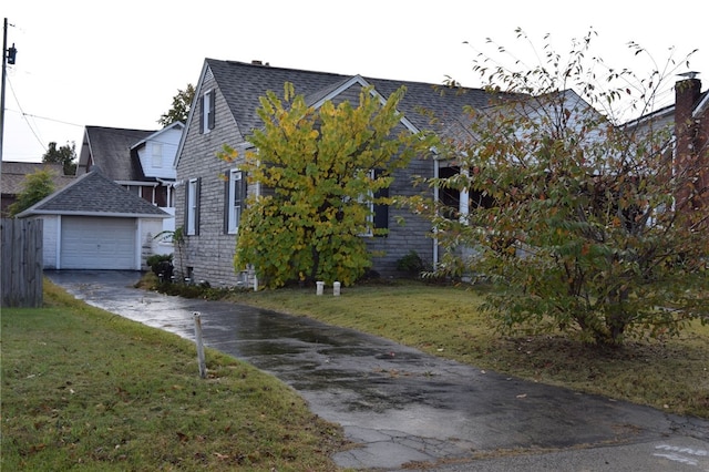 view of home's exterior with an outdoor structure, a garage, and a lawn