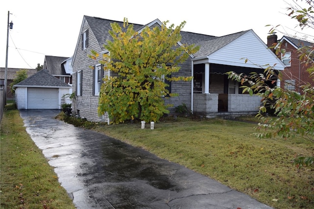 view of front of property with a garage, a front yard, and an outbuilding