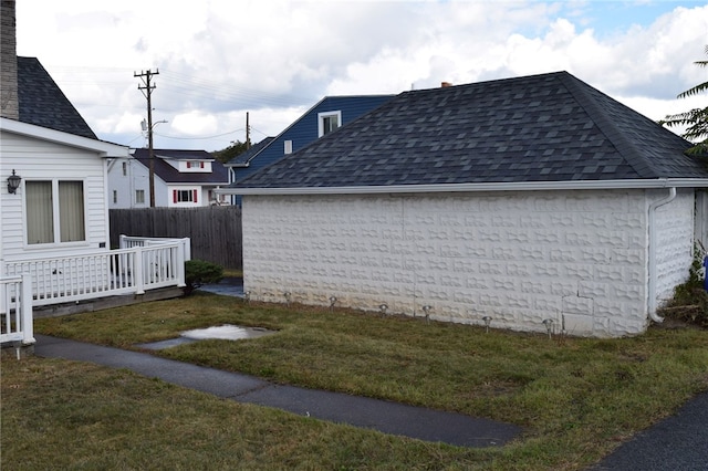 view of side of home with a deck and a yard