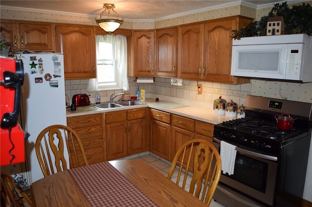 kitchen with light wood-type flooring, white appliances, sink, crown molding, and backsplash