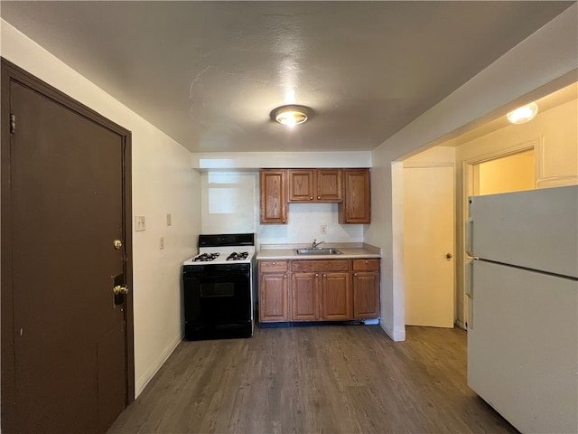 kitchen featuring sink, white appliances, and dark hardwood / wood-style flooring