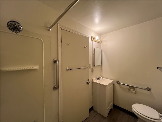 bathroom with vanity, toilet, a shower, and wood-type flooring