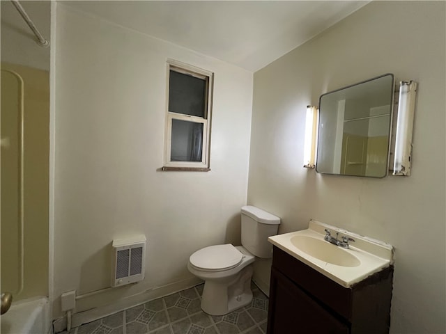 full bathroom with heating unit,  shower combination, toilet, vanity, and tile patterned flooring