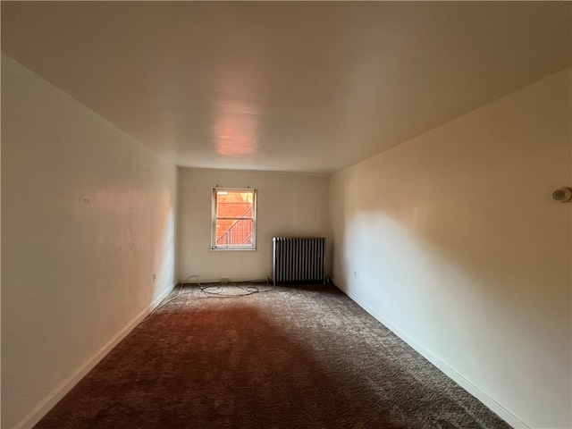 spare room with carpet and radiator heating unit