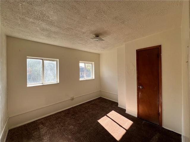 carpeted empty room with a textured ceiling