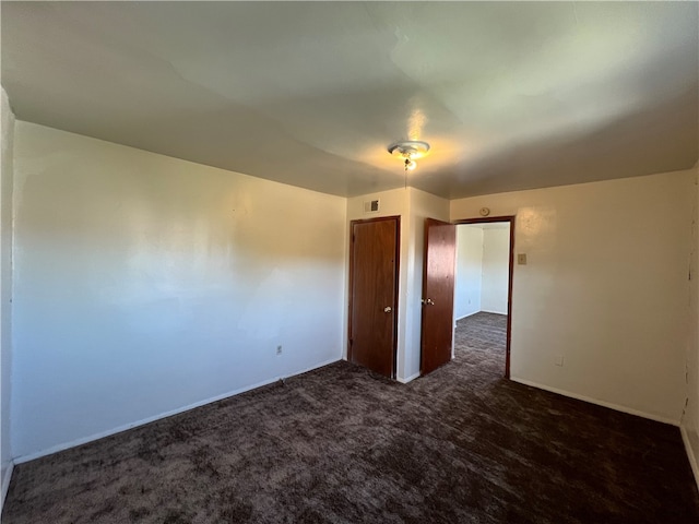 empty room featuring dark carpet