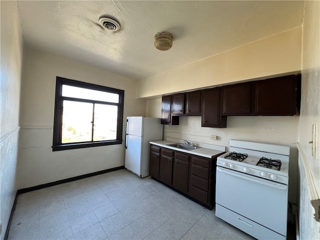 kitchen with sink, dark brown cabinets, and white appliances