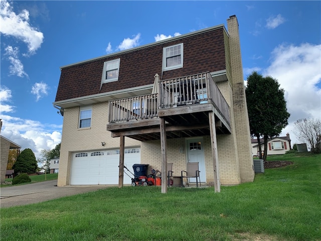 rear view of property featuring a yard, a garage, a deck, and central air condition unit