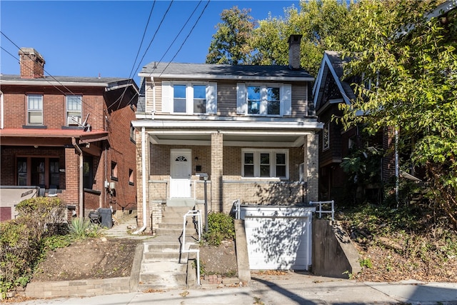 townhome / multi-family property featuring covered porch and a garage