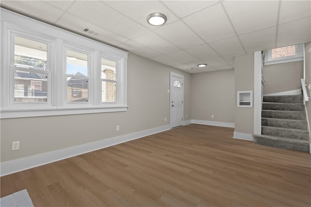 interior space with hardwood / wood-style flooring, a paneled ceiling, and a wealth of natural light