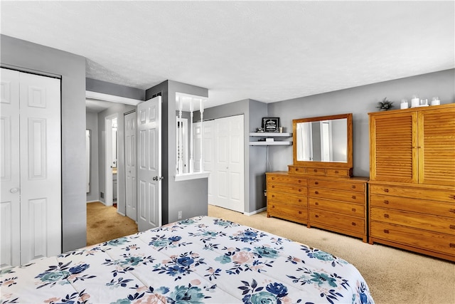 carpeted bedroom with multiple closets and a textured ceiling