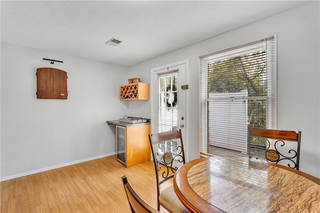 dining room with light hardwood / wood-style flooring and a textured ceiling