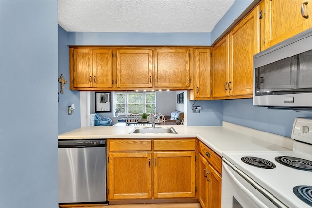 kitchen featuring appliances with stainless steel finishes, sink, and a textured ceiling