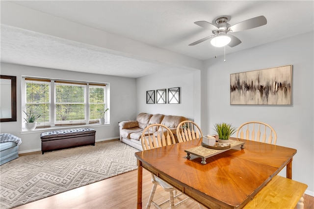 dining room featuring ceiling fan, a textured ceiling, and light wood-type flooring