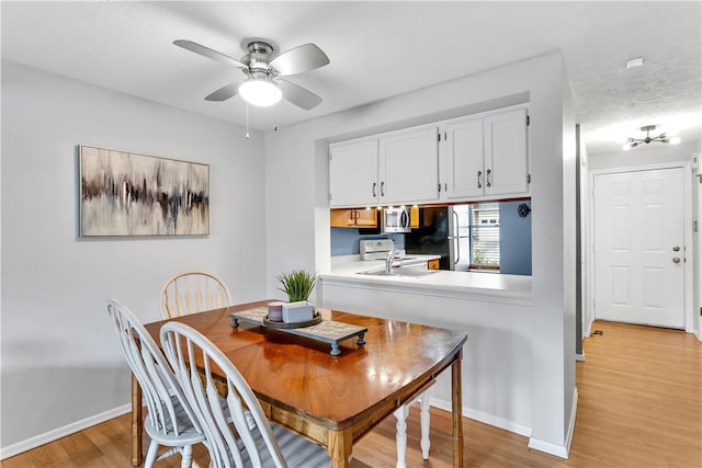 dining area with ceiling fan, a textured ceiling, and light wood-type flooring