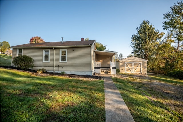 rear view of property featuring a yard and a shed