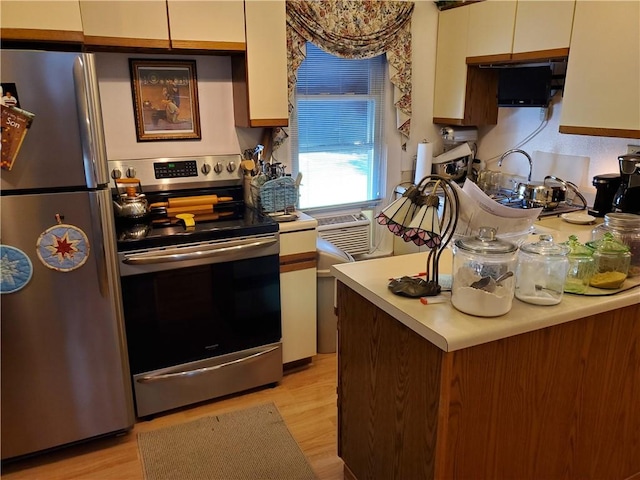 kitchen featuring white cabinets, light countertops, appliances with stainless steel finishes, and light wood-style flooring