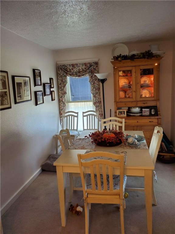 dining area featuring a textured ceiling and carpet