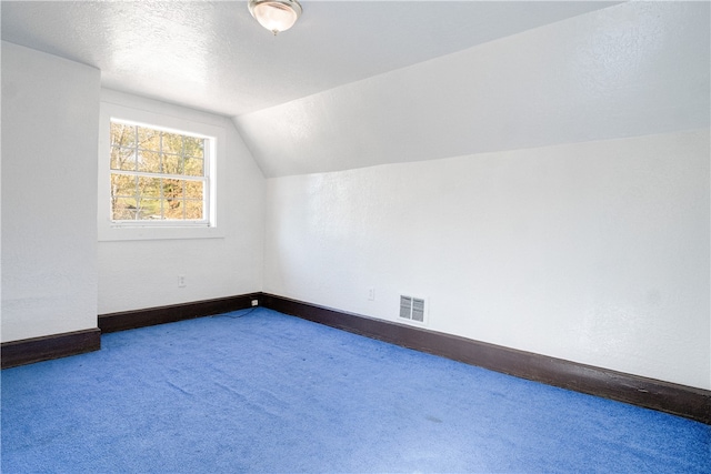 bonus room with carpet, a textured ceiling, and lofted ceiling