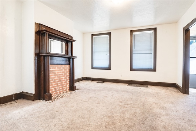 unfurnished living room with light carpet and a textured ceiling