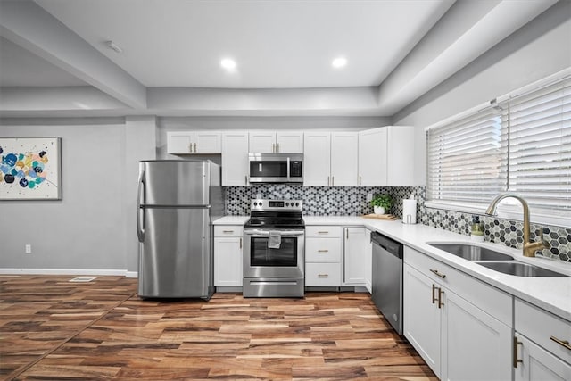 kitchen with white cabinetry, sink, stainless steel appliances, and backsplash