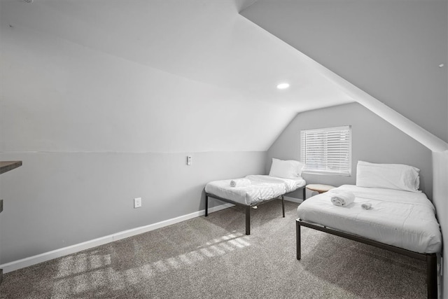 sitting room featuring carpet floors and vaulted ceiling