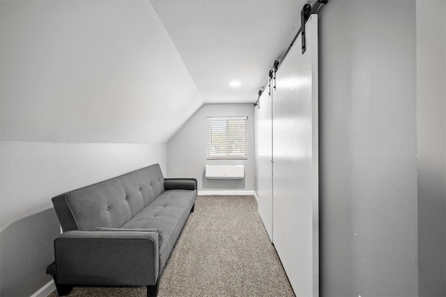 interior space with a barn door and vaulted ceiling