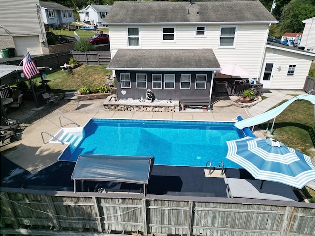 view of swimming pool with a water slide and a patio