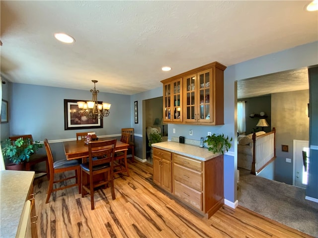 kitchen with a chandelier, hanging light fixtures, and light hardwood / wood-style flooring