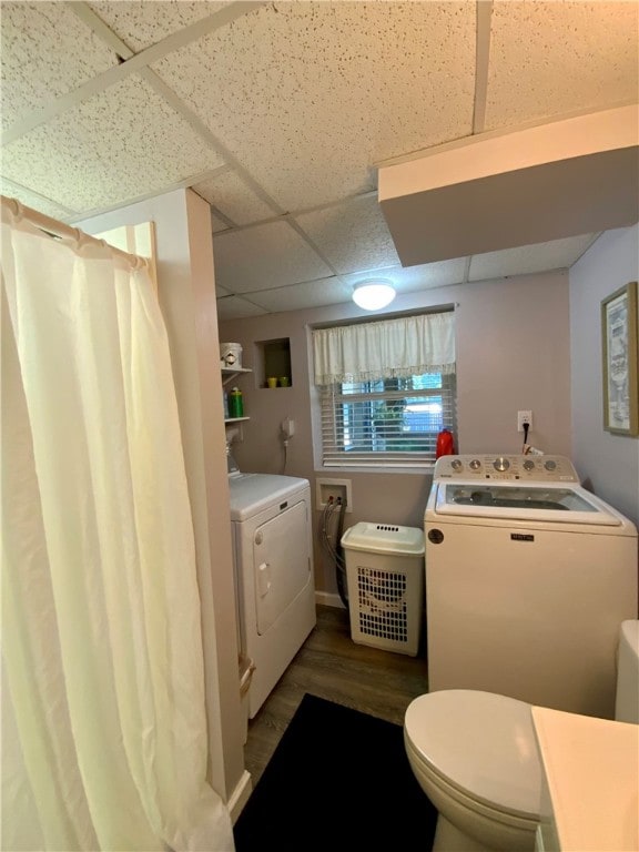 bathroom featuring a paneled ceiling, wood-type flooring, and washing machine and clothes dryer