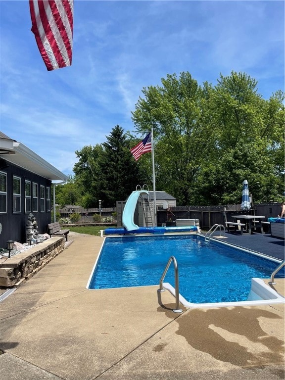 view of pool featuring a patio and a water slide