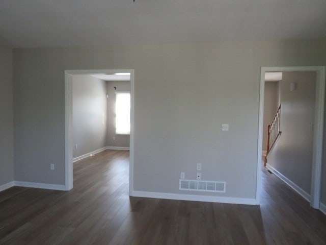 unfurnished room featuring dark wood-type flooring