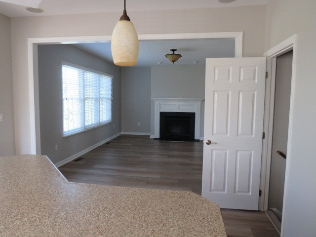 unfurnished living room with dark hardwood / wood-style flooring