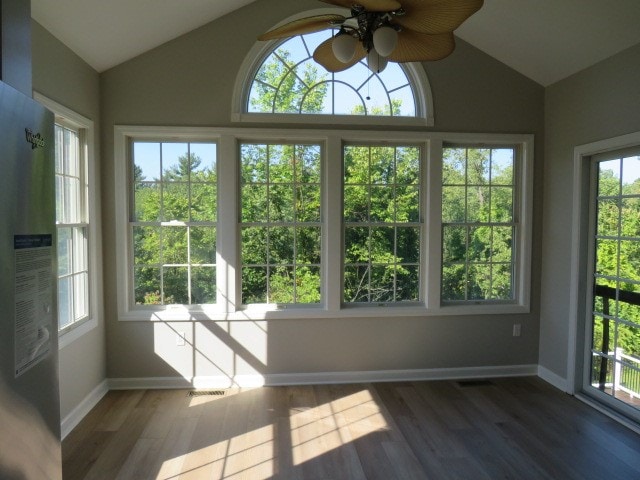 unfurnished sunroom with ceiling fan and vaulted ceiling