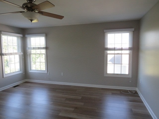 spare room featuring ceiling fan, plenty of natural light, and dark hardwood / wood-style floors