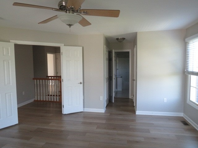 unfurnished room featuring ceiling fan, hardwood / wood-style floors, and a healthy amount of sunlight