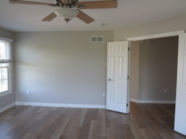 empty room featuring ceiling fan and dark wood-type flooring