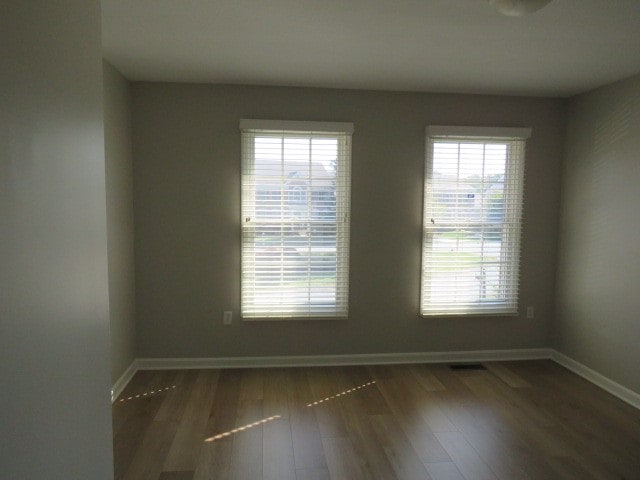 unfurnished room with dark hardwood / wood-style floors and a wealth of natural light