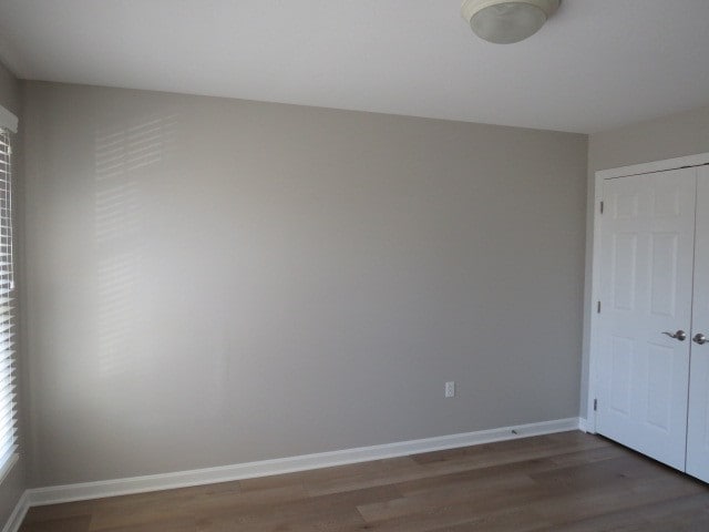 empty room with dark hardwood / wood-style flooring