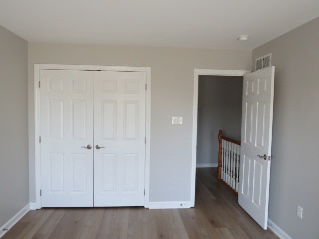 unfurnished bedroom featuring hardwood / wood-style flooring and a closet