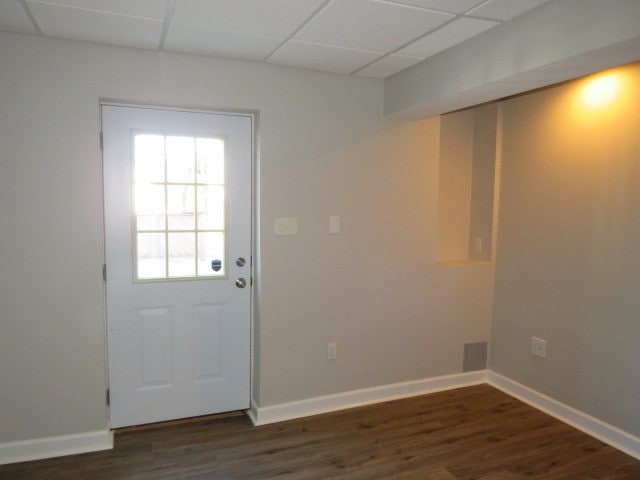 doorway to outside with a paneled ceiling and dark wood-type flooring