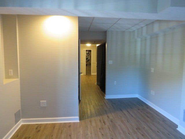 spare room featuring a paneled ceiling and hardwood / wood-style floors