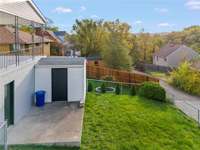 view of yard with a storage shed and a patio