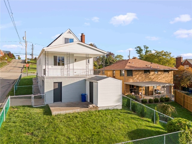 rear view of house featuring a storage shed and a lawn