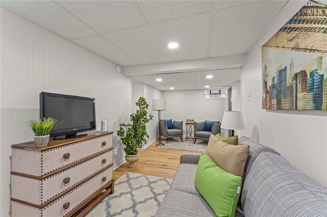 living room featuring a paneled ceiling and wood-type flooring