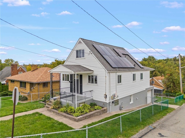 view of front of home featuring a front yard and solar panels