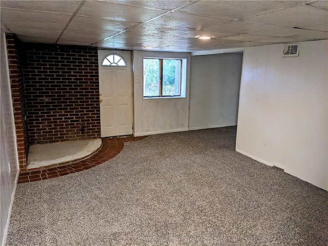 basement with carpet floors and a paneled ceiling