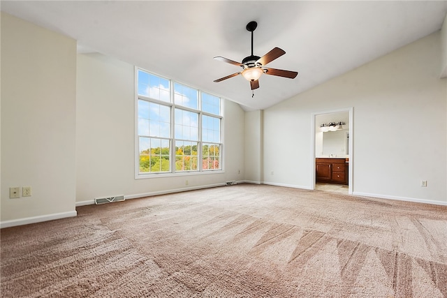 spare room featuring light carpet, ceiling fan, and vaulted ceiling